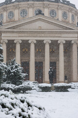 Winter snowfall photo in Bucharest. Beautiful detail view during a snowfall over Romanian Atheneum landmark building from Romania. Travel to Bucharest.