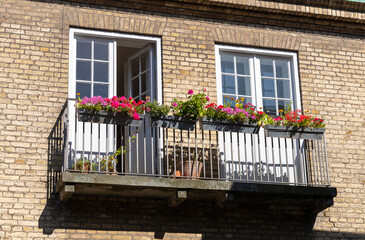 Fototapeta na wymiar Cozy balcony with flowers in a brick house.