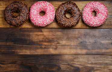 Chocolate and pink sweet donut on wooden table, breakfast donut