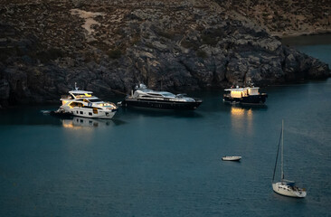 Expensive yachts are moored in the bay.