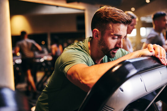 Tired man leaning on a treadmill