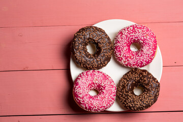 Chocolate and pink donut on a plate, delicious dessert