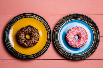 Chocolate and pink donut on a plate, delicious dessert