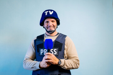 Reporter with bulletproof vest holding a microphone in studio.