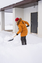 Man is clearing the snow near house and on staircases hovelling at the winter season. Winter storm and season specific