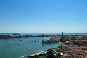 Fototapeta na wymiar Aerial view from St Mark bell tower Campanile of the old town of Venice, Veneto, Italy, Europe. Looking at Basilica di Santa Maria della Salute. UNESCO World Heritage Site. Urban tourism in summer