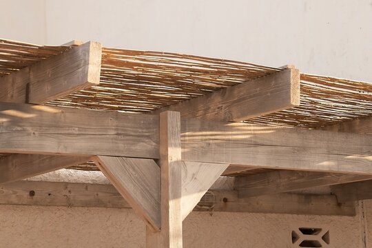 Vigas de madera de un alero en una casa de playa. Primer plano del detalle de la construcci&oacute;n con ca&ntilde;as. Las Negras, Almer&iacute;a, Espa&ntilde;a.