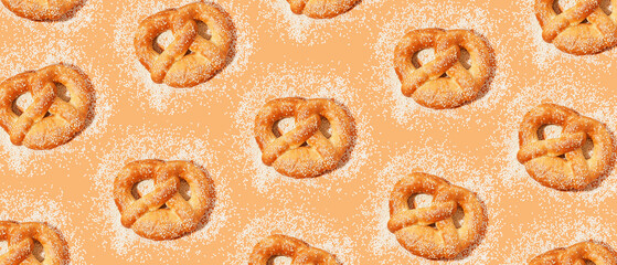 Many pretzels with sesame seeds on orange background. Pattern for design