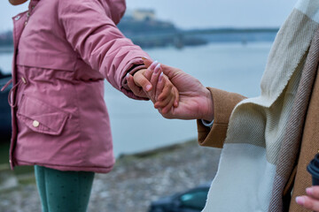 Mother's hands tenderly holding her daughter's hand, a timeless capture of the warmth and...
