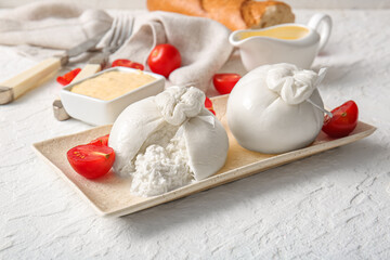 Plate with tasty Burrata cheese on white background