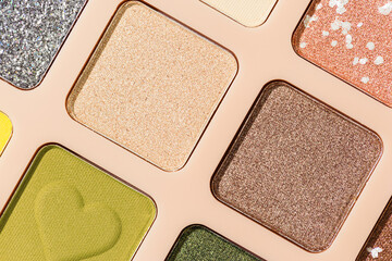 Top view texture pattern with different eye shadow swatches, multi colors palette in beige plastic...