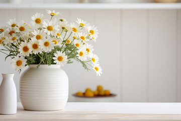 Daisies in white vase on table 