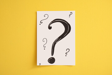 Paper with question marks on yellow background