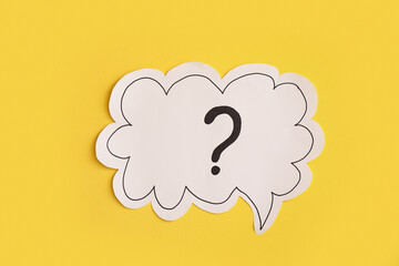 Paper speech bubble with question mark on yellow background