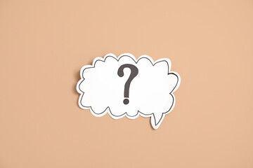 Paper speech bubble with question mark on beige background