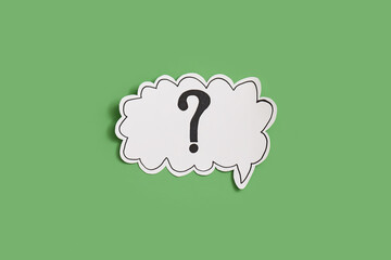 Paper speech bubble with question mark on green background