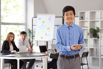 Young Asian businessman with tablet computer at meeting in office