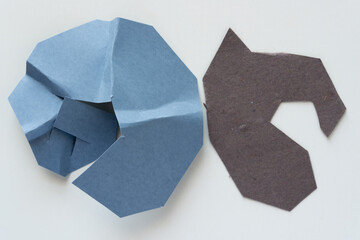 two cut paper shapes on blank paper