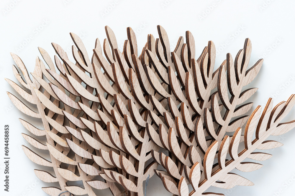 Wall mural overlapping decorative wooden leaf cutouts on paper