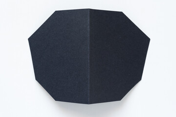 polygonal folded black paper shape on white