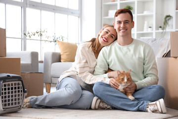 Young couple with cute cat in room on moving day