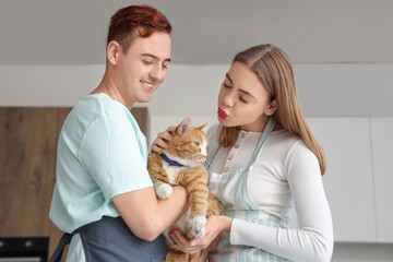 Young couple with cute cat in kitchen