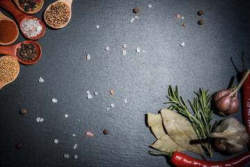Many different spices and fresh vegetables for cooking on a black background, still life with...