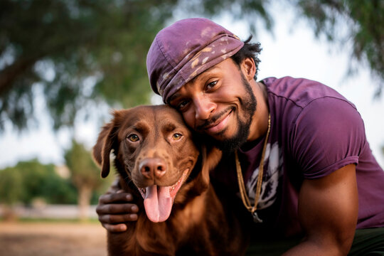 Smiling bearded man with his affectionate brown dog in a park setting