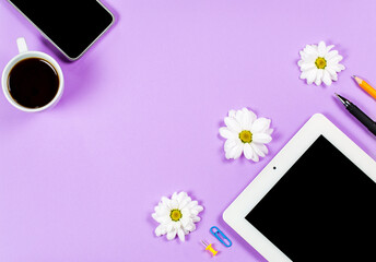 Stationery items, a cup of coffee and a tablet on a purple background, office