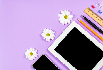 Stationery items and tablet on a purple background, office