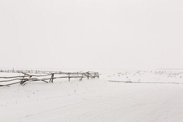 A crooked village fence, winter snowy landscape