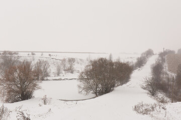 Hills near a snowy lake and a road in winter