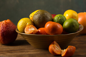 A variety of colorful citrus fruits on the bowl, rustic still life