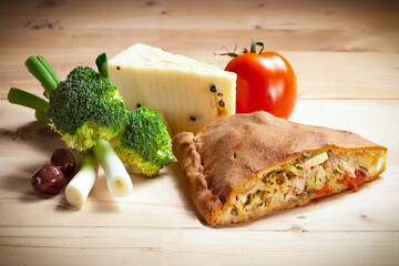 Slice of Sicilian scacciata with broccoli, fresh onion, olives, and Tuma cheese