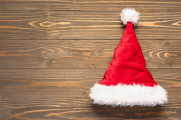 Obraz na płótnie Canvas Santa Claus hat on brown wooden background
