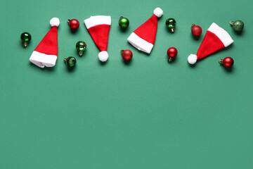 Santa Claus hats and Christmas balls on green background