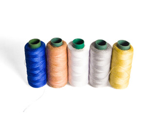 collection of sewing thread spools on a white background