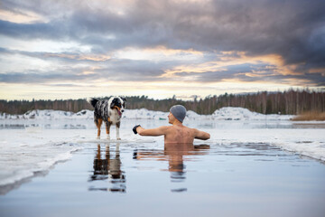 Strong man taking an ice bath. Swimming in a frozen lake during winter. Healthy cold swim. - obrazy, fototapety, plakaty