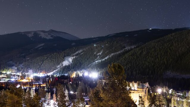 Time lapse of a mountain and night sky in Colorado. Snow grooming equpment can be see moving on a nearby ski resort.