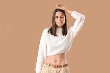 Young woman in stylish clothes on brown background - obrazy, fototapety, plakaty