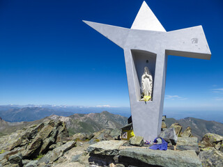Summit cross of Viso Mozzo with scenic view of mountain ranges of Cottian Alps, Cuneo, Piemonte,...