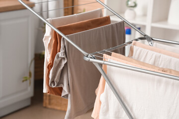 Dryer with clean clothes in laundry room, closeup