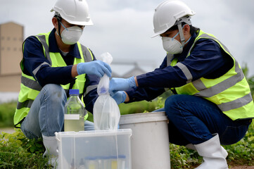 Environmental Engineers Take Water Samples that smells bad Near Farmland at Natural Water Sources put them in bottle and keep in plastic bags, Water Contaminated by Toxic Suspicious Pollution Sites.