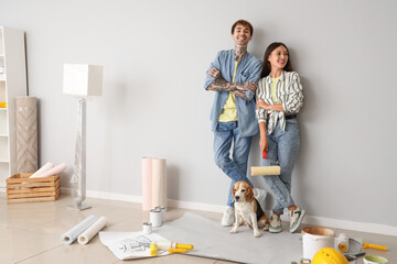 Young couple with paint roller and Beagle dog during repair in their new house