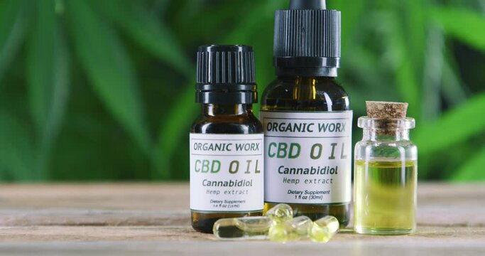 Cbd oil, weed and hemp in bottle for health benefits, herbal medicine or medical wellness. Prescription, Organic herbs or cannabis extract for pain relief, therapy and healthcare with relax on table