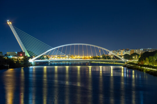Vista nocturna del r&iacute;o Guadalquivir de Sevilla con el puente de la Barqueta y el del Alamillo, iluminados al anochecer