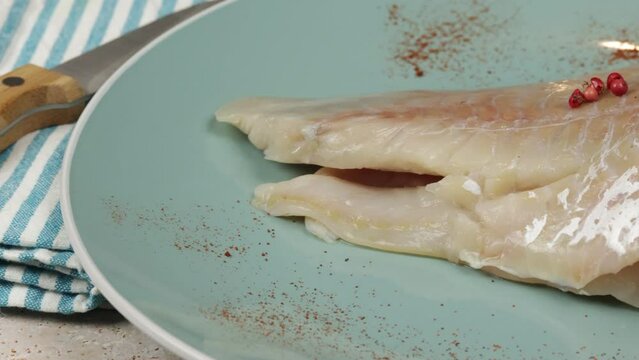 filet de lieu noir cru, en gros plan, dans une assiette
