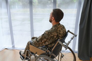 Unhappy military man sitting in wheelchair.