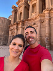 Young European boys taking a selfie next to Petra Monastery. Middle-aged heterosexual couple...