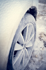 Ice crystals formed on the spokes of the car wheel. The spokes of the car wheel are covered with...